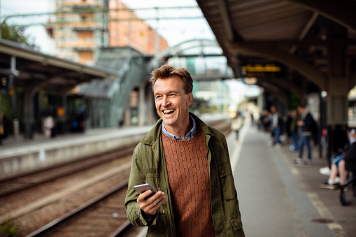 Close up of a man using a phone at a train station