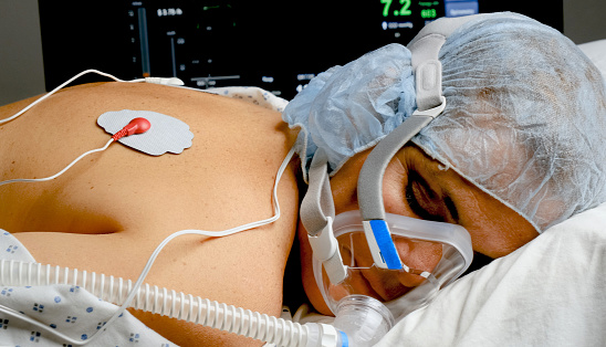 Sleeping caucasian mature woman connected to a ventilator mask