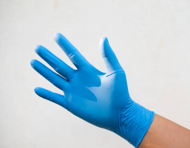 istock Close up hand in blue glove on white background in science concept. 1219089381