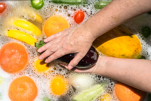 Fruit and vegetables washing in soapy water for coronavirus disinfection.