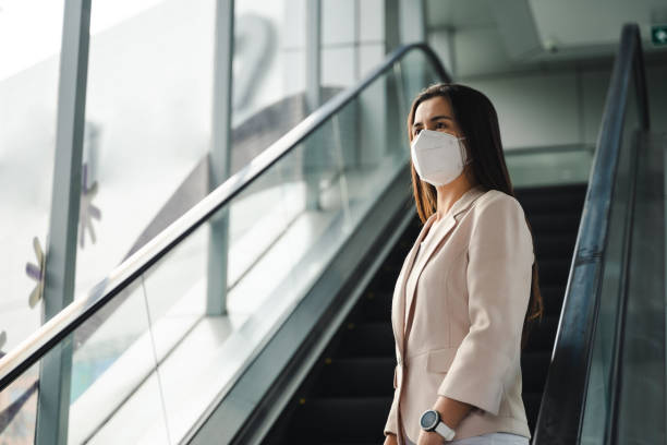 asiatische frau trägt n95 maske zum schutz der verschmutzung pm2.5 und virus. covid-19 coronavirus und luftverschmutzung pm2.5 konzept. - quit scene stock-fotos und bilder