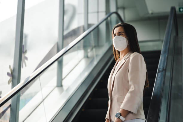 mujer asiática que usa máscara n95 para proteger la contaminación pm2.5 y virus. covid-19 coronavirus y contaminación atmosférica concepto pm2.5. - quit scene fotografías e imágenes de stock