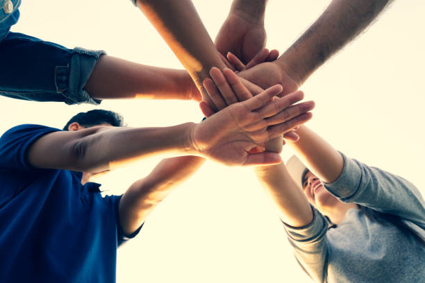 istock People putting their hands together. Friends with stack of hands showing unity and teamwork. Friendship happiness leisure partnership team concept. 1219096387