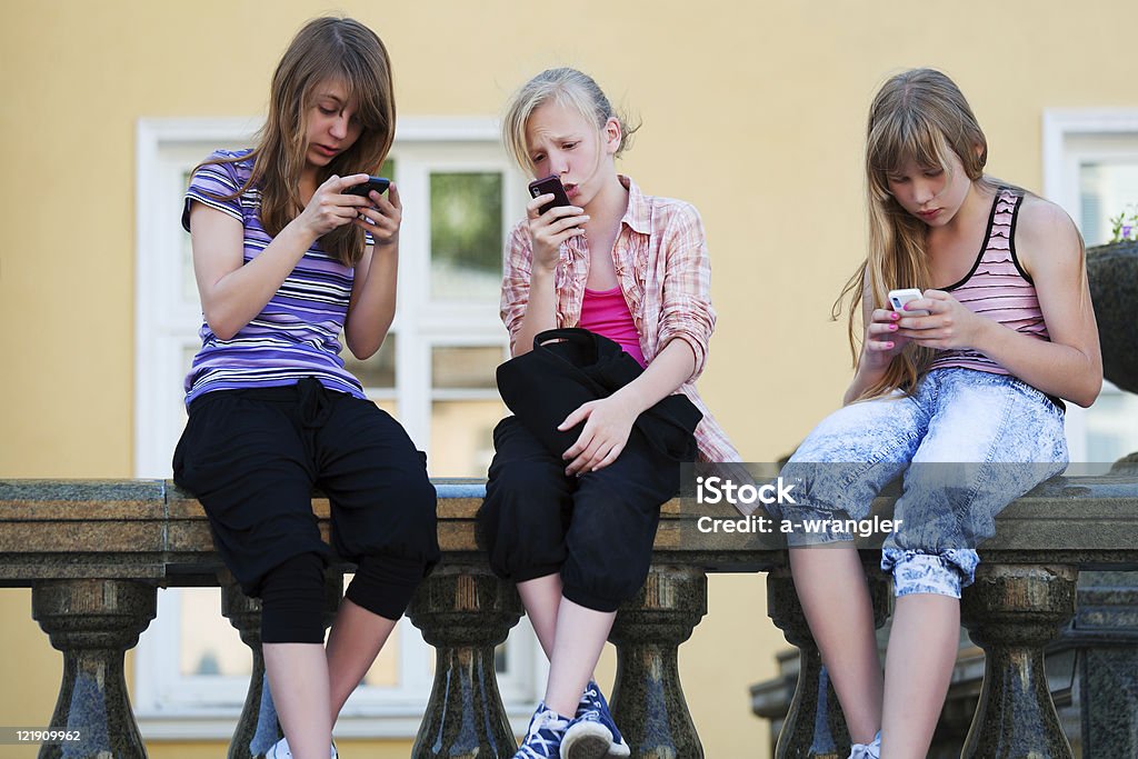 Teenage girls calling on the mobile phones  Adult Stock Photo