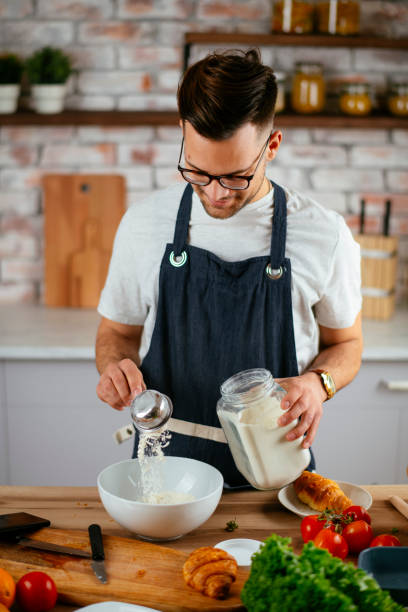 istock Young man making delicious food in kitchen. 1219100447