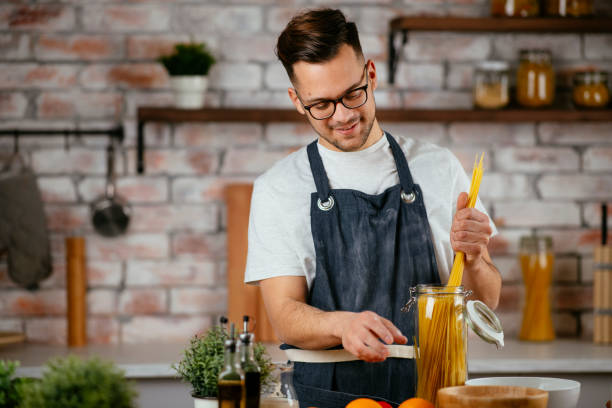 istock Young man making delicious food in kitchen. 1219100498