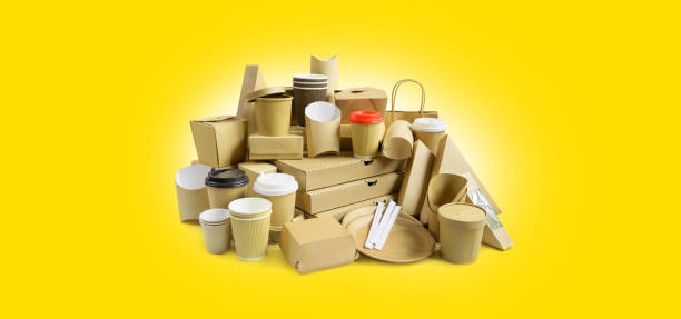 istock Many Various take-out food containers, pizza box, coffee cups in holder and paper boxes on yellow background. 1219103190