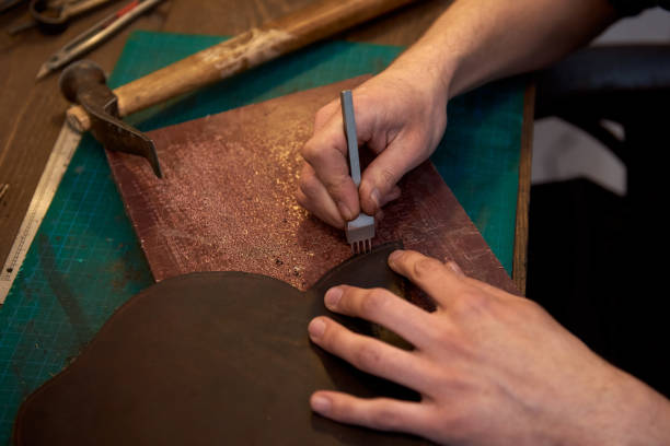 istock The leatherman holding crafting tool and working with genuine leather at work desk. 1219105620
