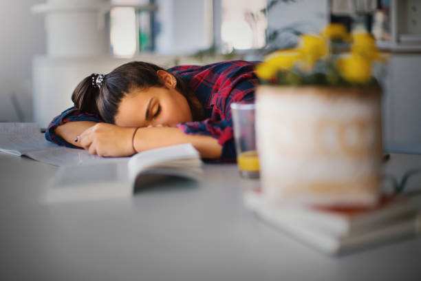 un'adolescente che dorme sulla sua scrivania. - sleeping high school desk education foto e immagini stock