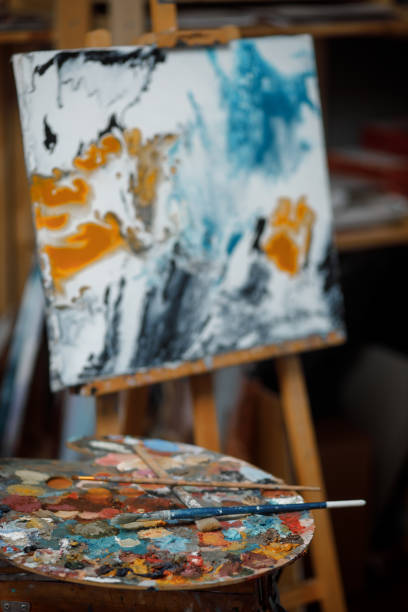 istock Easel, brushes, paints and palette in an art workshop 1219108895