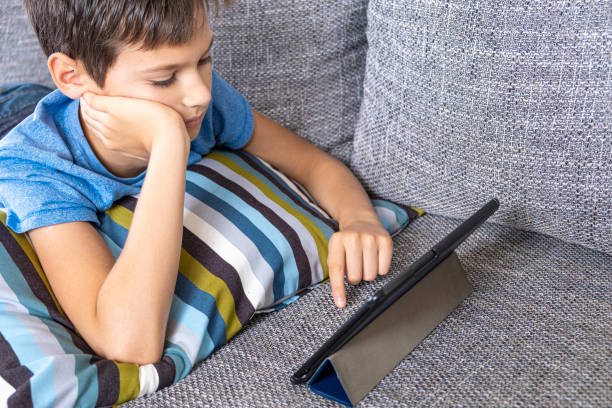 istock Prelying on sofa with digital tablet computer at home. Technology, ditance education, online learning, playing games concept 1219110023