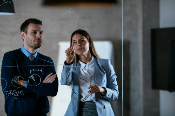 istock Business people drawing graph on glass wall 1219110077