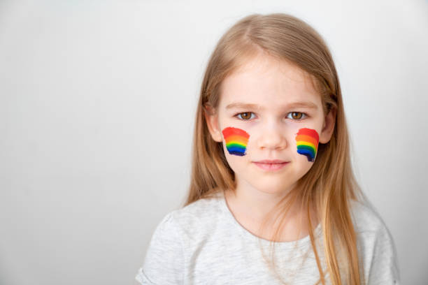 istock small girl painted cheeks a rainbow. stay home. 1219111217
