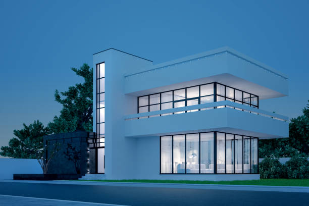 istock Modern house with white plaster with a balcony and a high staircase, in the cold evening light with warm light from the Windows against the background of trees and a white fence 3D stock illustration 1219111434