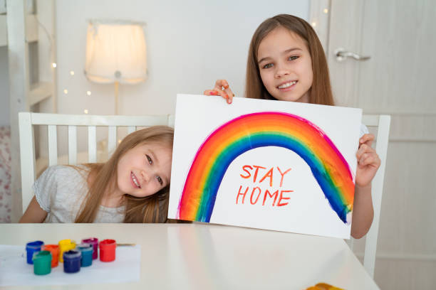 istock small girls write stay home. Flashmob. Rainbow 1219112456