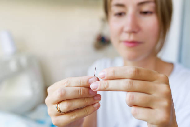 젊은 재봉사는 바늘과 실로 작동합니다. - embroidery thread sewing threading 뉴스 사진 이미지