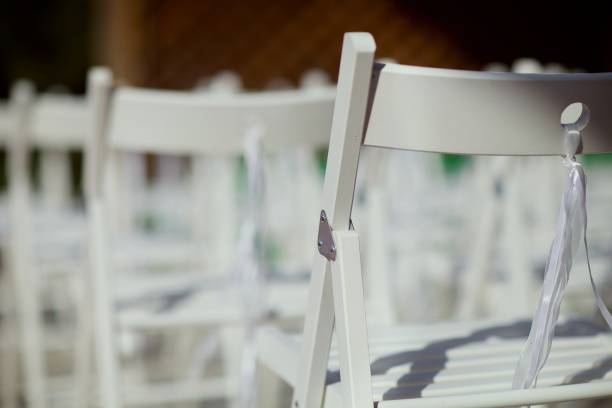 istock White folding wooden chairs Terje stand in a row outdoors. Wedding ceremony 1219116860