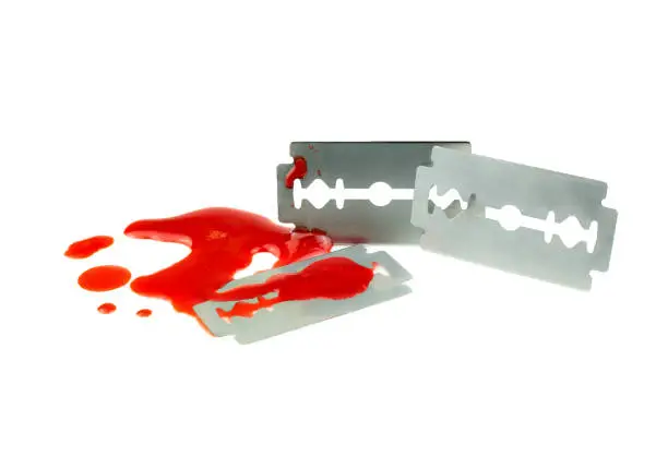 Photo of Photo of Razor blade with a drop of blood on white background