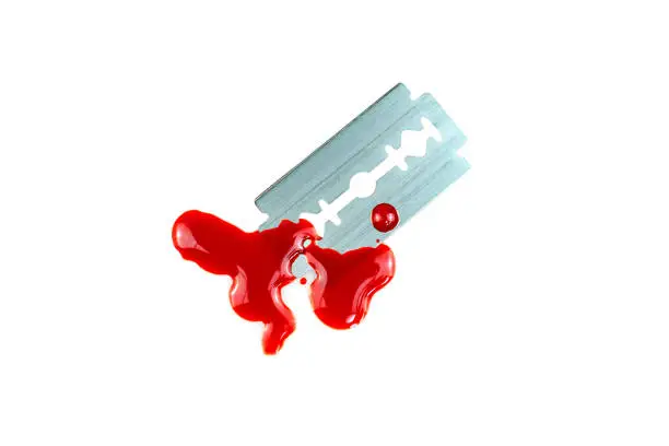 Photo of Photo of Razor blade with a drop of blood on white background
