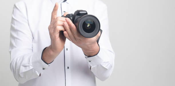 istock camera in hands of a man in white clothes with copy space 1219117513
