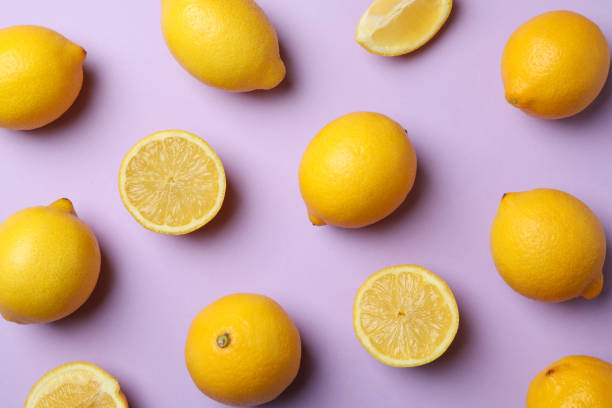 istock Flat lay with lemons on violet background. Fresh fruit 1219122266