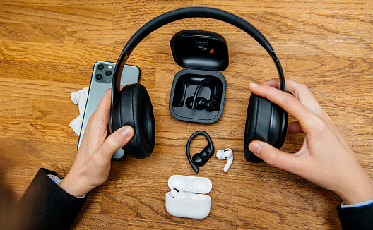 Paris, France - Oct 30, 2019: Overhead view of woman hands unboxing new Apple Computers AirPods Pro headphones with Active Noise Cancellation for immersive sound next to Beats pro and Powerbeats sport pro