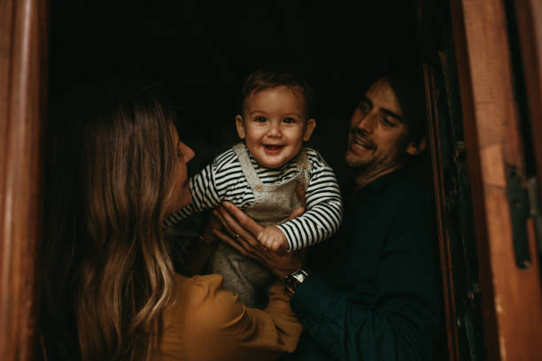 istock Happy smiling baby boy looking at camera, while their parents play with him. 1219122654