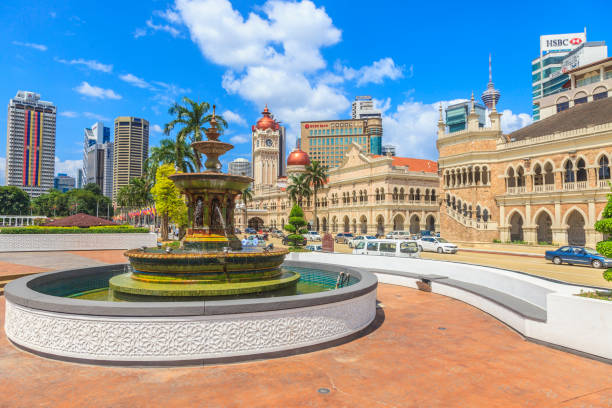 Fountains at Merdeka Square in Kuala Lumpur Photo of the fountain in Merdeka Square in Kuala Lumpur overlooking the Sultan Abdul Samad Building during the day in a blue sky photographed in Malaysia in November 2013 merdeka square stock pictures, royalty-free photos & images