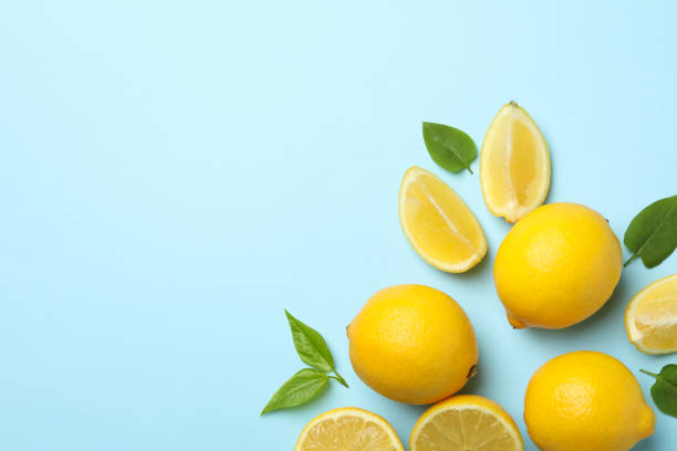 istock Fresh lemons with leaves on blue background, top view. Ripe fruit 1219123566