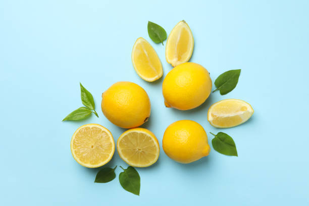 istock Fresh lemons with leaves on blue background, top view. Ripe fruit 1219123964