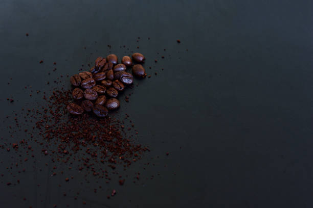 Coffee beans and ground powder on black background. Top view with copy space