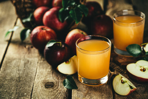 istock Apple juice in glass on rustic wood background 1219124481