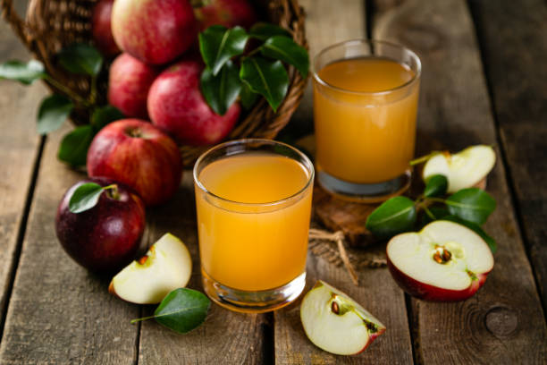 istock Apple juice in glass on rustic wood background 1219124502