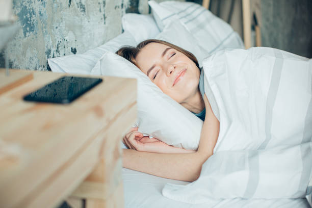 istock Pleased lady smiling while sleeping in soft bed stock photo 1219127146