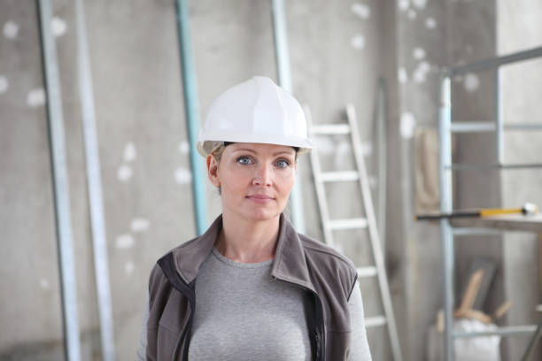 istock woman construction worker builder portrait wearing white helmet on  interior site building background with scaffolding and ladder 1219127498