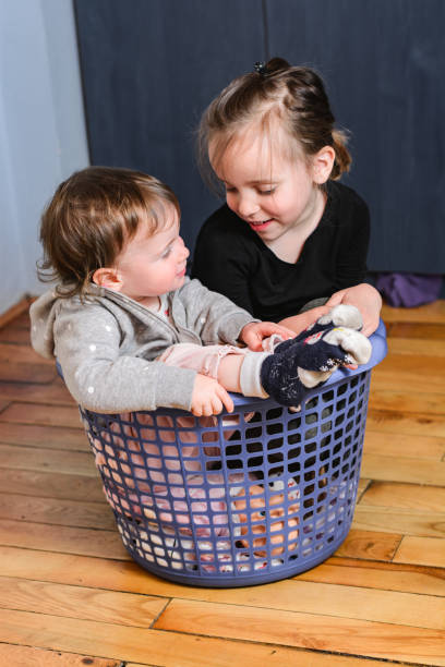 istock Children sitting in laundry basket 1219128653