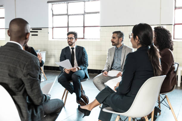 istock Cheerful managers sitting in chairs with paper documents 1219129984