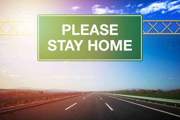 istock Plase Stay Home Road Sign 1219131518