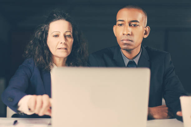 istock Serious business partners looking and pointing at laptop 1219133092