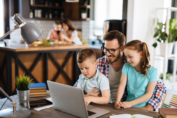 istock Kids having fun at home, playing with their father, using laptop 1219133217