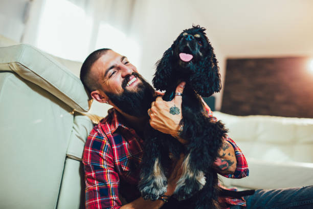 Handsome man with cute dog at home