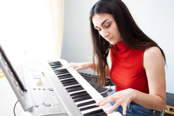 istock Teenager learning piano at home 1219135490