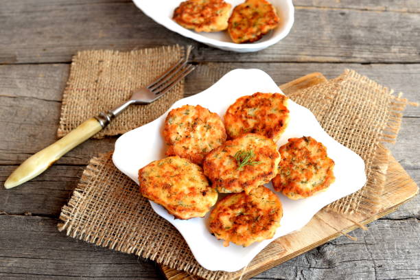 istock Fried red fish cutlets on a plate and on a cutting board, a fork on a burlap on an old wooden background. Delicious patties cooked with chopped salmon filet, eggs, onion and dill and fried in olive oil 1219135930