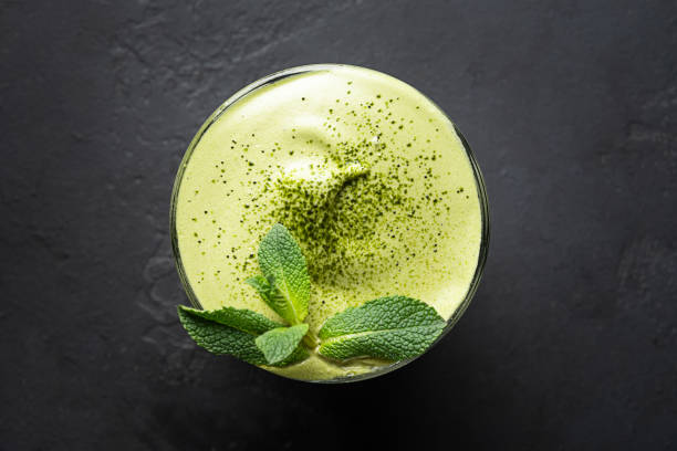 ダルゴナアイスティー抹茶のグラスは、黒にミントを飾ります。 - green tea ice tea ice cube mint ス��トックフォトと画像