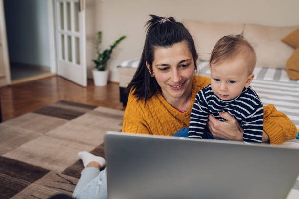 istock Young mom working and holding her baby boy 1219139590