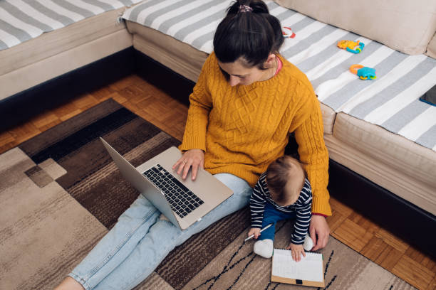 istock Mother babysitting her baby boy and working online 1219139595