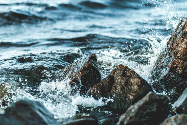 istock The surf waves breaking on stones 1219139834