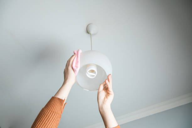 istock woman cleaning chandelier 1219141527