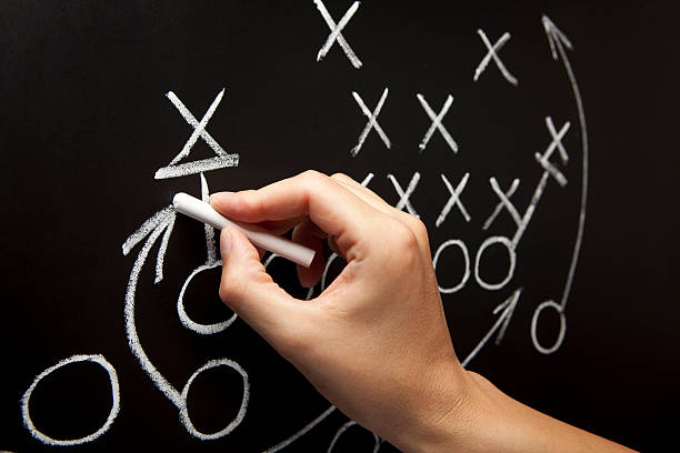 Man drawing a game strategy on a chalkboard