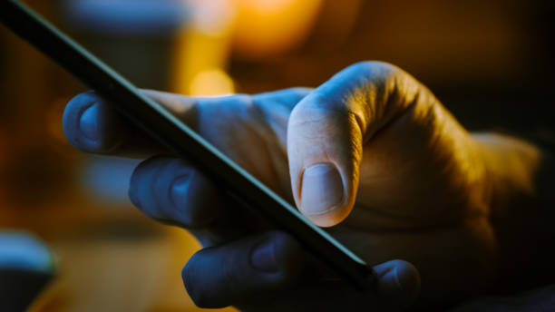 istock Person Holding Touch Screen Smartphone Device and Typing Message. Concept of Email Writing, Chatting in Social Media Apps, Sending an SMS, Taking Note. Close-up Macro Side View 1219143105